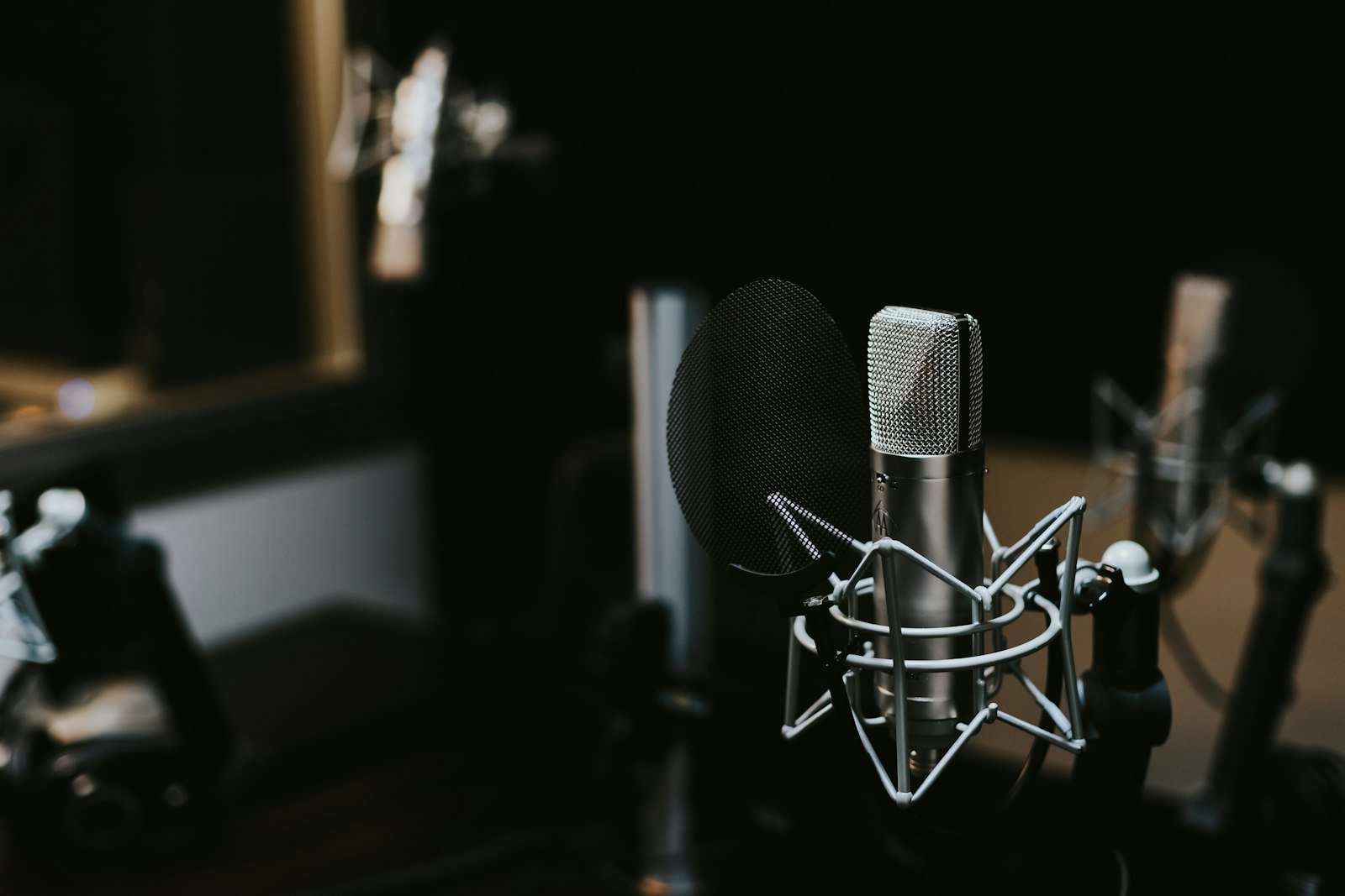 Studiomikrofon mit Popschutz in einem dunklen Aufnahmestudio